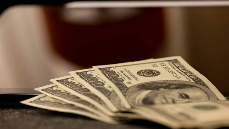 Gráfico de inflación en Estados Unidos con billetes de dólar y flechas ascendentes, reflejando precios altos y gasto desacelerado en agosto.