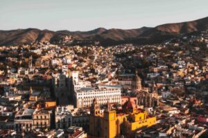 Zona industrial moderna en Guanajuato con fábricas y vehículos de carga, simbolizando inversión extranjera y desarrollo económico