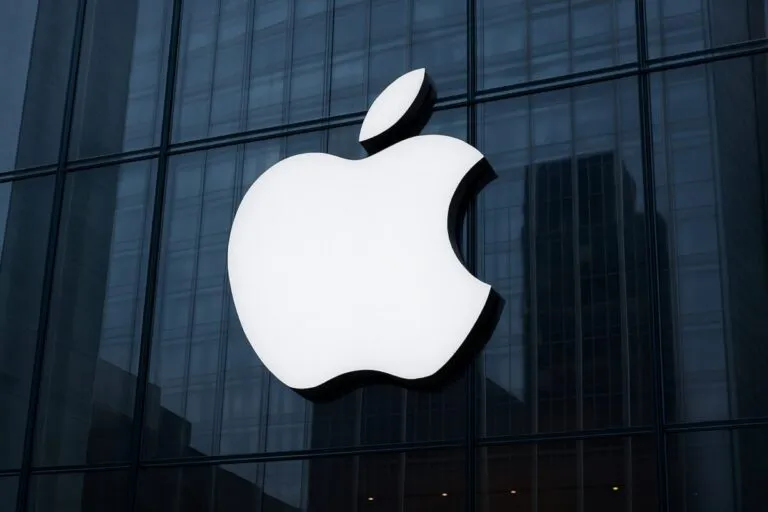 Logo de Apple sobre fachada vidriada en estilo corporativo, ilustrando el avance del iPhone satelital con tecnología espacial