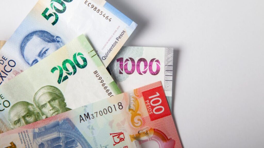 Billetes y gráficos financieros que representan el comportamiento del peso mexicano frente al dólar en una jornada de bajo volumen