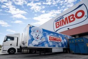 Camión de Grupo Bimbo estacionado frente a planta industrial en México, proyectando potencial bursátil según análisis financiero