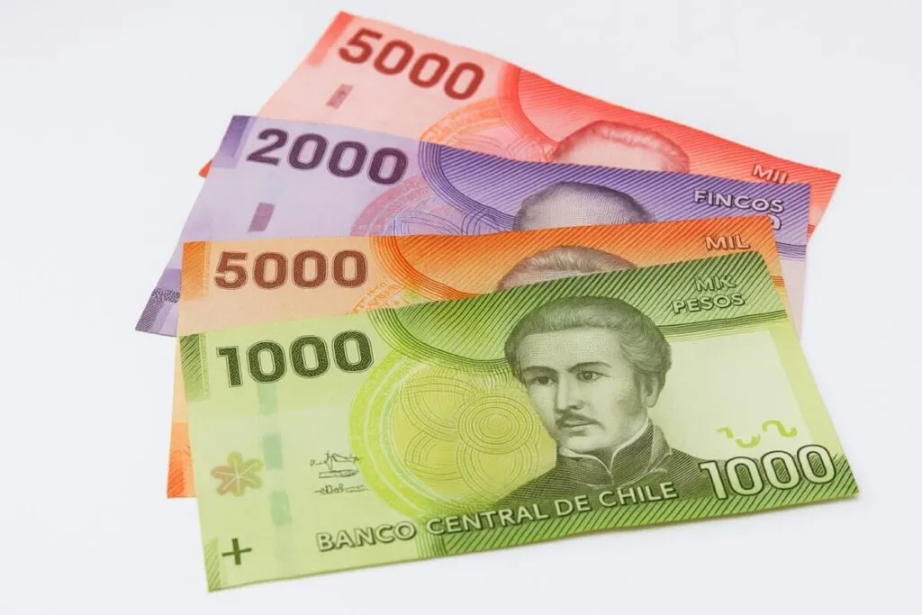Billetes de diferentes denominaciones del peso chileno dispuestos en abanico, con fondo claro