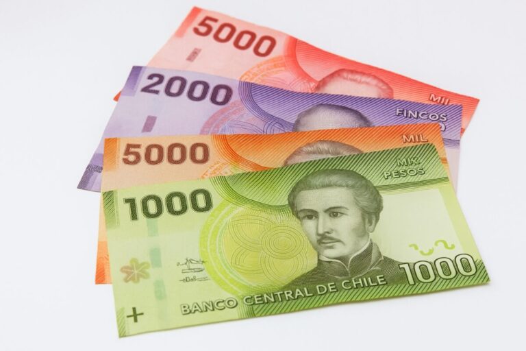 Billetes de diferentes denominaciones del peso chileno dispuestos en abanico, con fondo claro