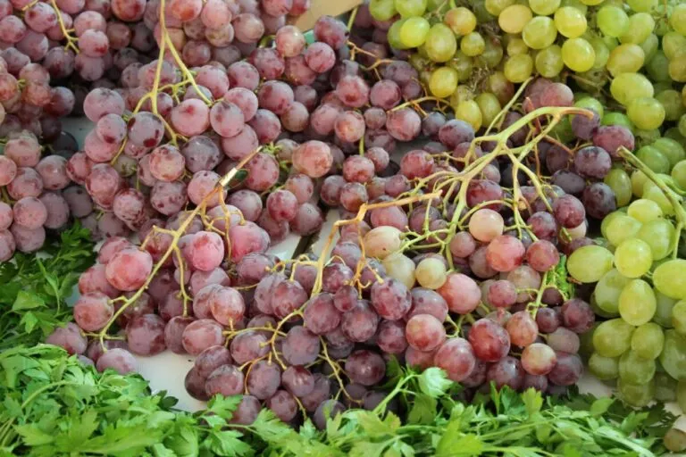 Puesto de uvas importadas en un mercado mexicano mostrando precios altos por demanda