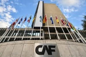 Edificio de CAF con banderas internacionales, representación institucional de foro con compradores globales