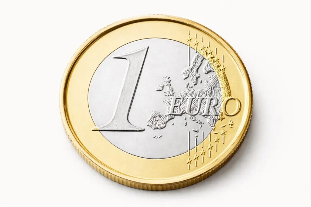 Fotografía profesional de una moneda de 1 euro, fondo blanco, estilo editorial moderno