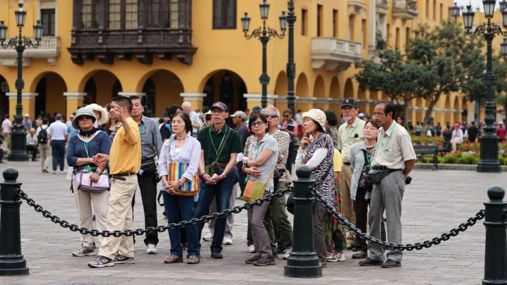 Viajeros asiáticos recorren un destino cultural mexicano mientras elementos de gastronomía, arquitectura y transporte aéreo completan la escena.