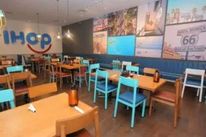 Interior de un IHOP con una mesa de desayuno y pancakes, con énfasis en la experiencia del consumidor.