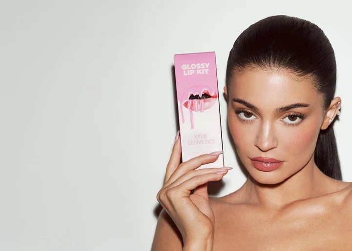 Kylie Jenner con productos de Kylie Cosmetics, en una composición editorial que contraste la etapa original de Lip Kits con la actual.
