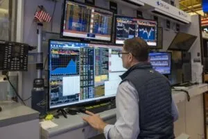 Pantallas con gráficos financieros que representan la relación entre los rendimientos de los bonos estadounidenses y el comportamiento de las bolsas de valores.