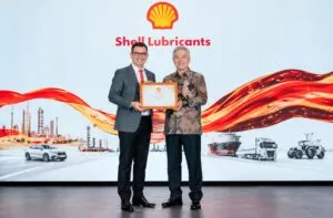Envases de lubricantes para motores junto a maquinaria industrial y componentes automotrices en un entorno de producción moderno.
